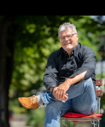 Sole Runner founder Thorsten Ludwig seated outdoors wearing casual clothes and his own shoes