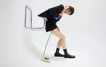 Person sideways in office wear on phone