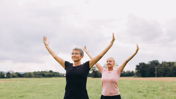 Two women outdoors with arms outstretche