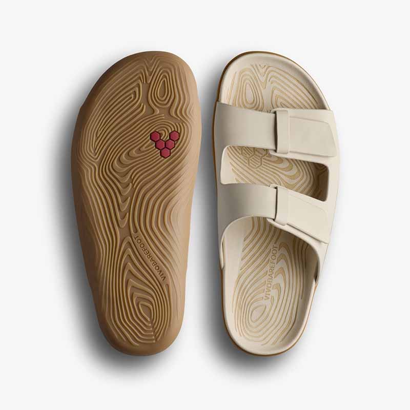 Pair of Vivobarefoot Women's Sandals Sensus Yin Slide - Sand, one showing the sole view and the other showing the top view.