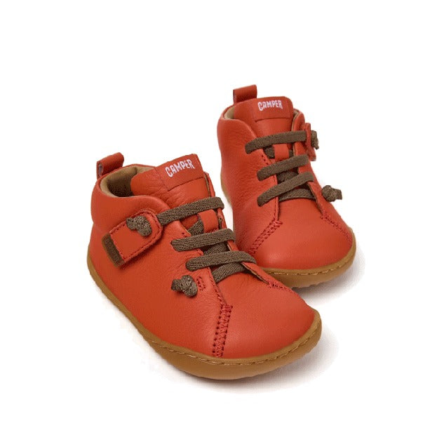 Pair of Camper Kids First Peu Boots in orange, angled view showing front, outer and inner side.
