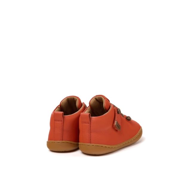 Pair of Camper Kids First Peu Boots in orange, angled view showing outer side and rear.