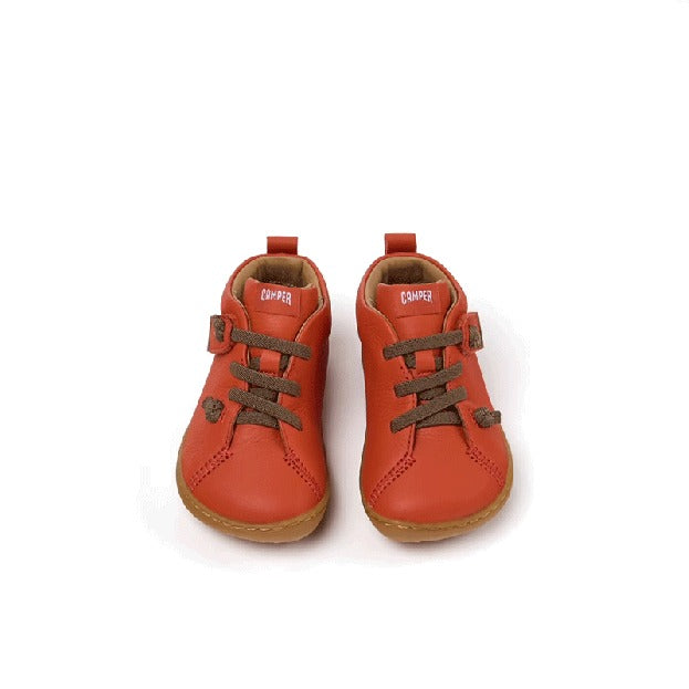 Pair of Camper Kids First Peu Boots in orange, front view.