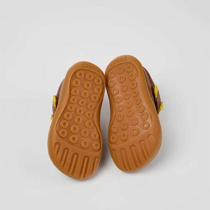 Pair of Camper Kids Peu Boots in green, sole view.