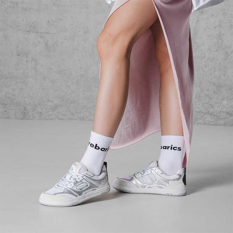 Person wearing Be Lenka Adults Barebarics Trainers Dropsta - White and Silver with white Barebarics socks.