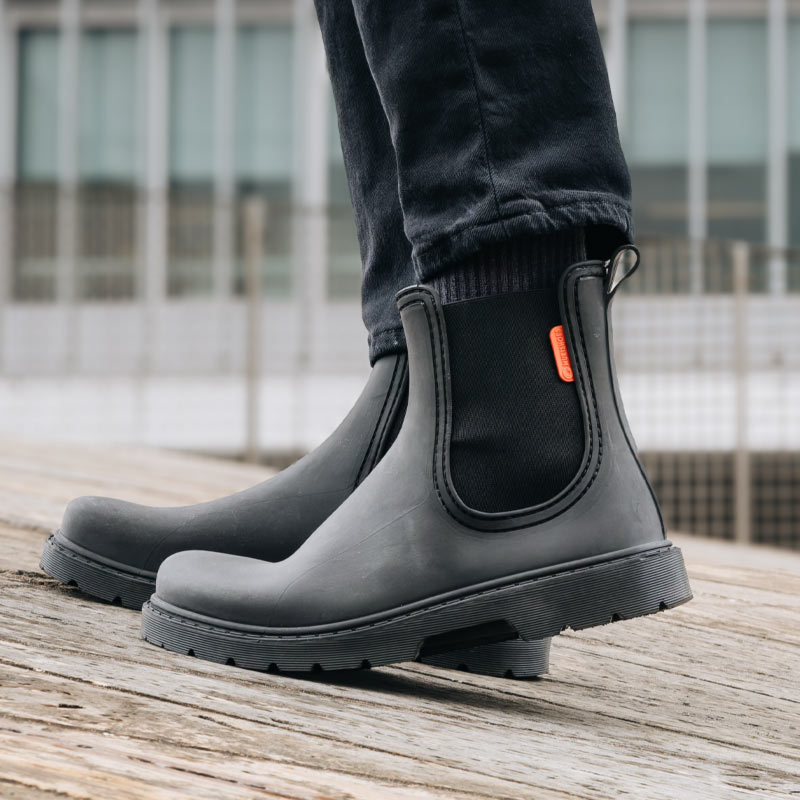 Person wearing Mukishoes Galocha Wellington Boots - Black, side view.