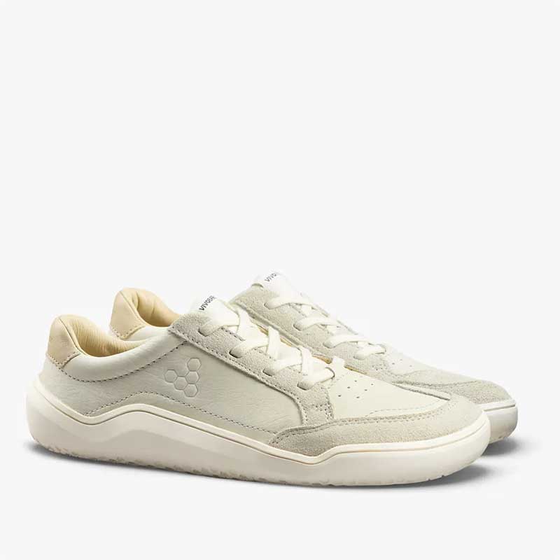 Pair of Vivobarefoot Junior Trainers Gobi - Limestone, angled view showing outer side and front.