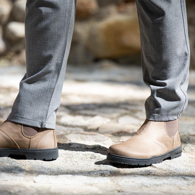 Person wearing El Naturalista Barefoot Arizona Nomada Chelsea Boots - Stone with grey trousers.