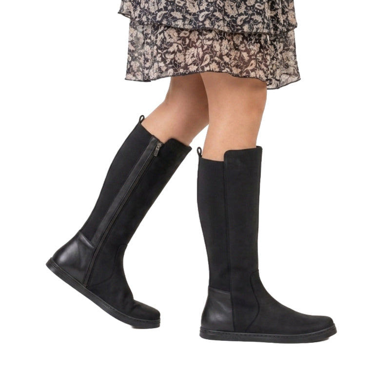 Person wearing Peerko Women's Regina II Boots - Black (Wider Calf), side view.