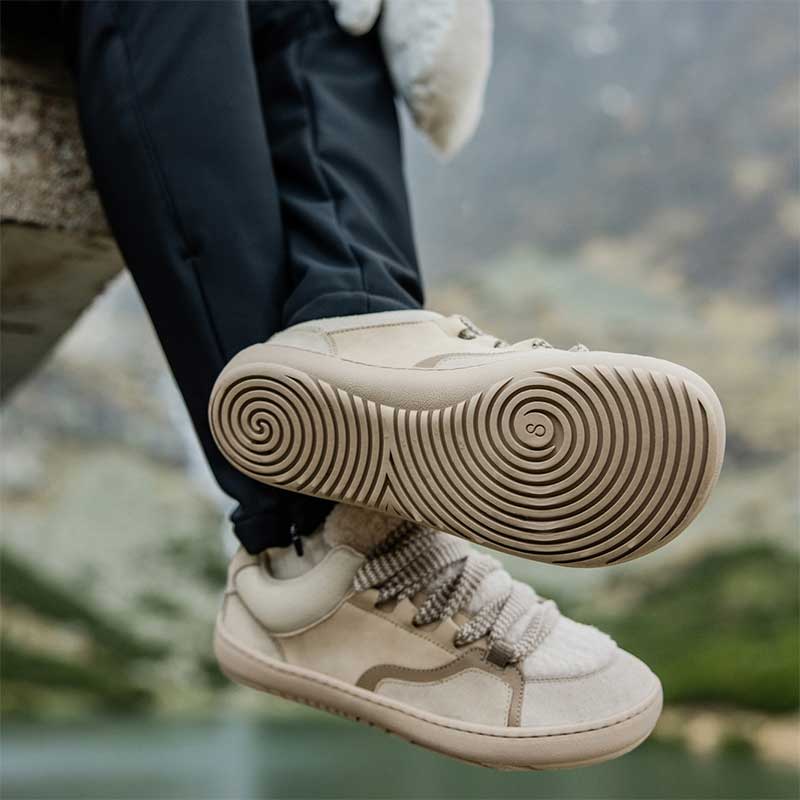 Person wearing Shapen Women's Teddy Trainers - Beige, showing the sole and outer side view.