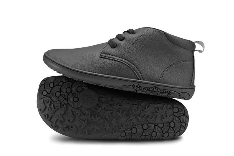 Pair of PaperKrane Kids Vegan Biro School Shoes in black, one showing the outer side, the other on it's side showing the sole.