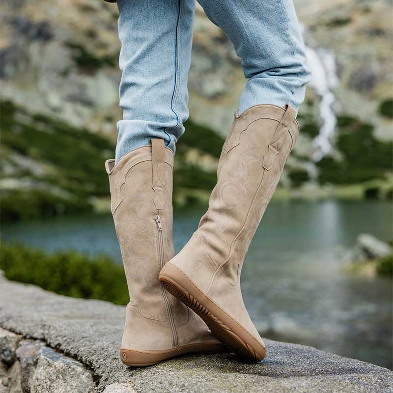 Person wearing Shapen Women's Arizona Cowboy Boots - Beige with jeans, side view.