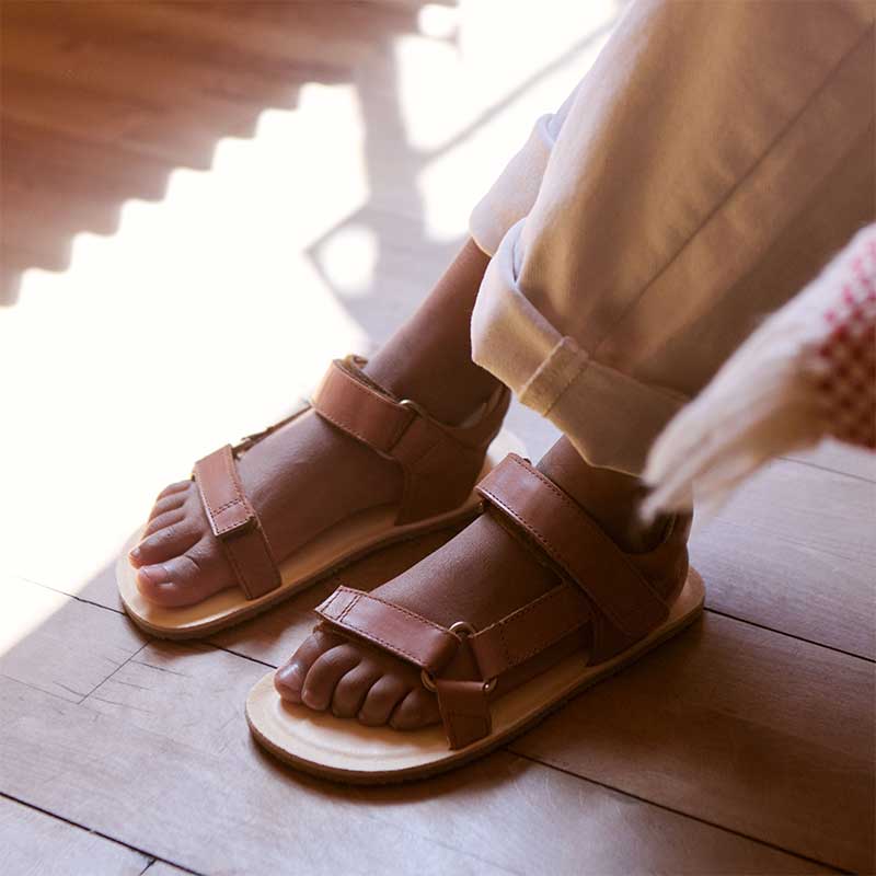 Person wearing Bundgaard Kids Sandals Haven - Cognac with cream trousers