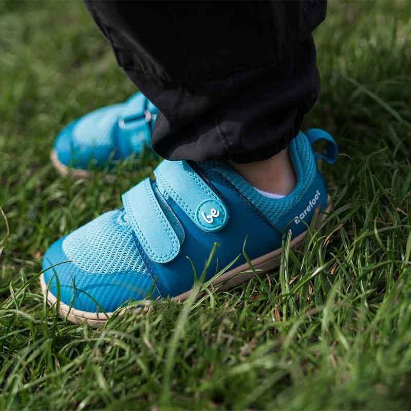 Person wearing Be Lenka Kids Trainers Bounty - Aqua with black trousers standing on grass