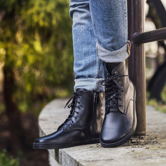 Person wearing Peerko Adults Boots Breeze - Black with denim jeans.