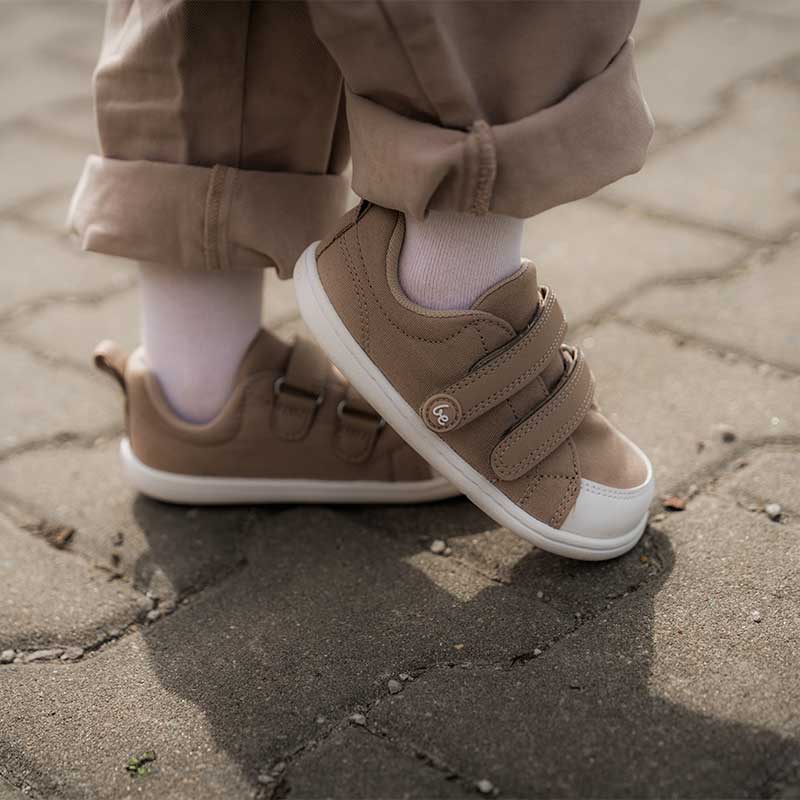 Person wearing Be Lenka Kids Trainers Canvi - Light Brown with brown trousers, inner and outer side view