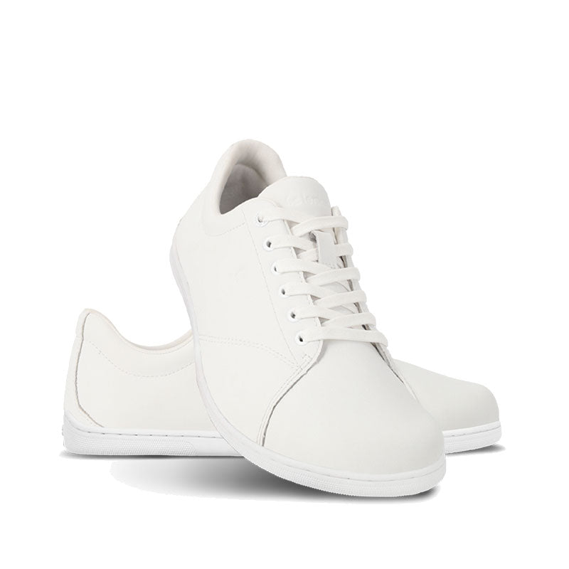 Pair of Be Lenka Adults Trainers Core - All White, one angled and leaning showing the outer side, the other partially showing the inner side