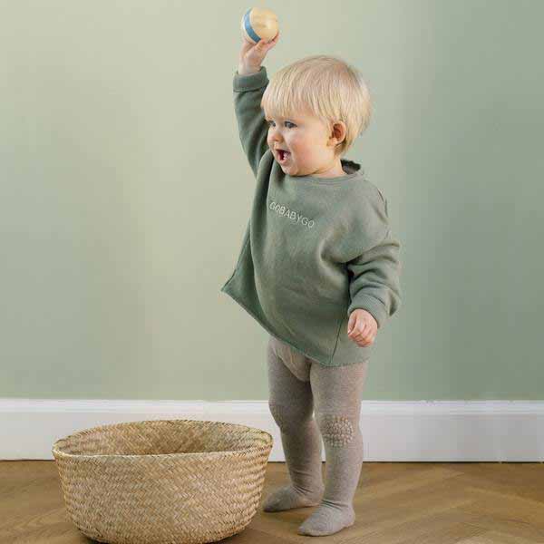 Child wearing Go Baby Go Crawling Tights in sand.