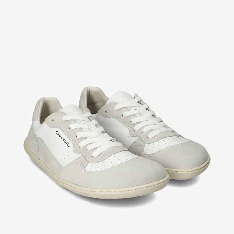 Pair of Groundies Adults Nova GO1+ Trainers - White/Off-White, angled view showing outer side and front.