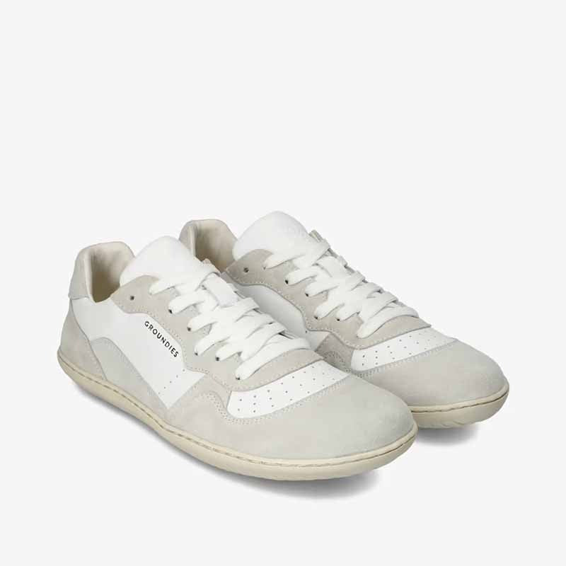 Pair of Groundies Adults Nova GO1 Trainers - White/Off-White, angled view showing outer side and front.