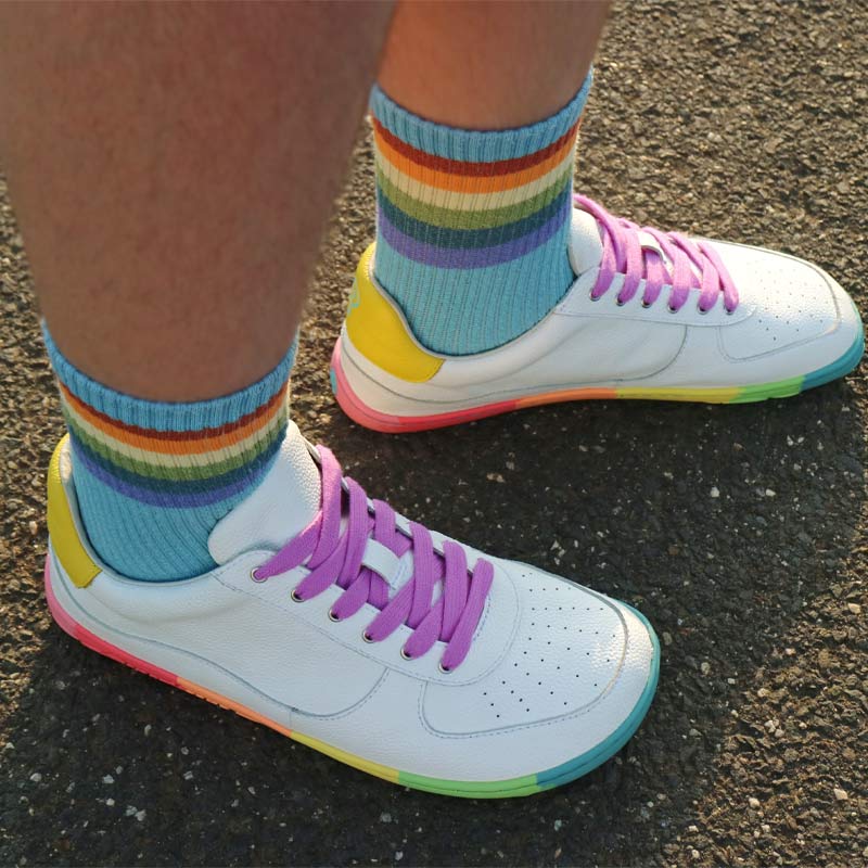 Person wearing PaperKrane Adults Neon Low Trainers in white with blue stripey socks.