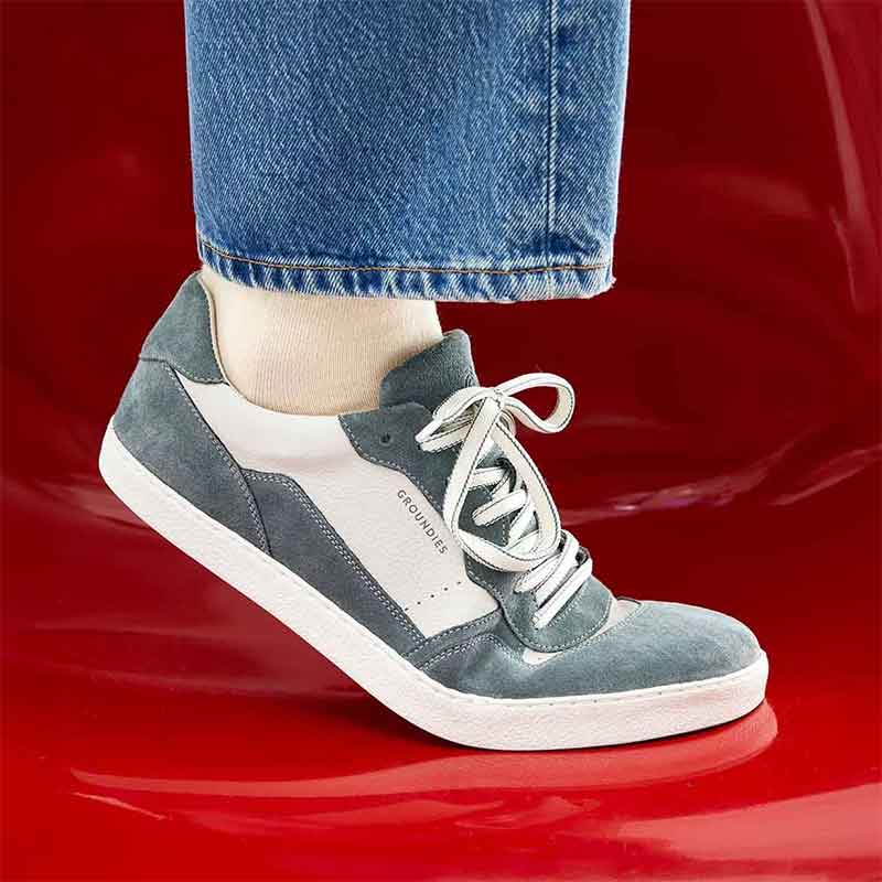 Person wearing Groundies Adults Nova GS1 Trainers in sage green with jeans.