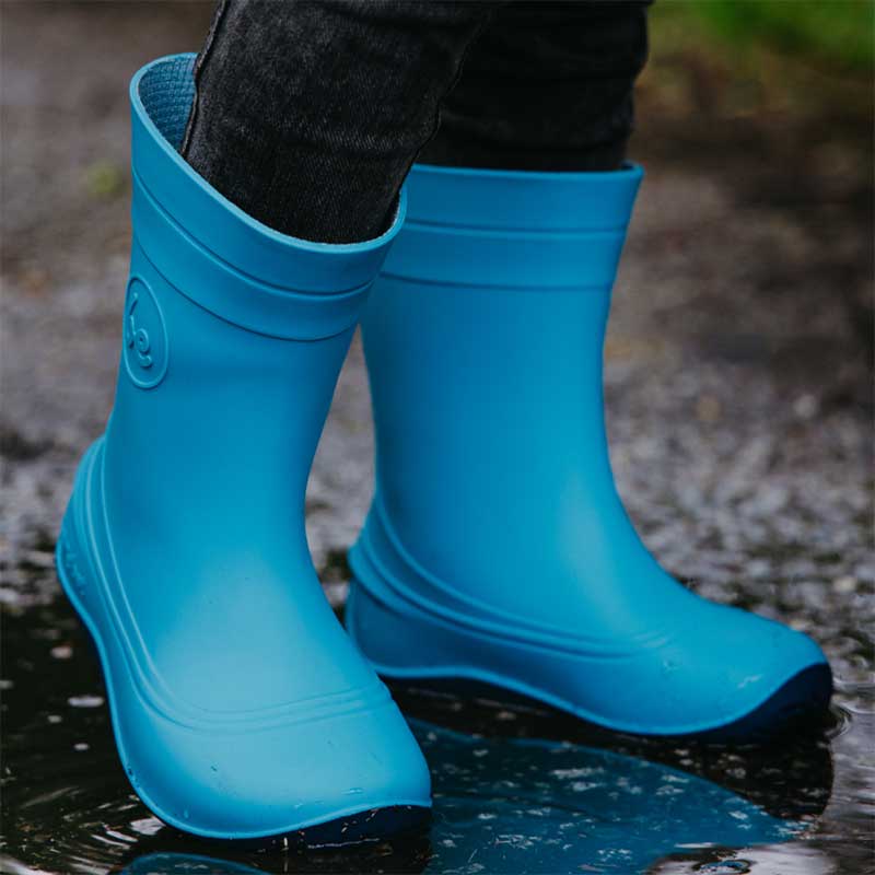 Person wearing Be Lenka Kids Wellies Pudds - Aqua Blue with black jeans