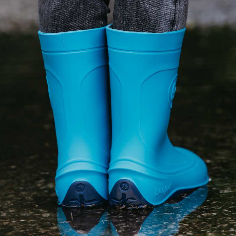 Person wearing Be Lenka Kids Wellies Pudds - Aqua Blue in puddle, rear view
