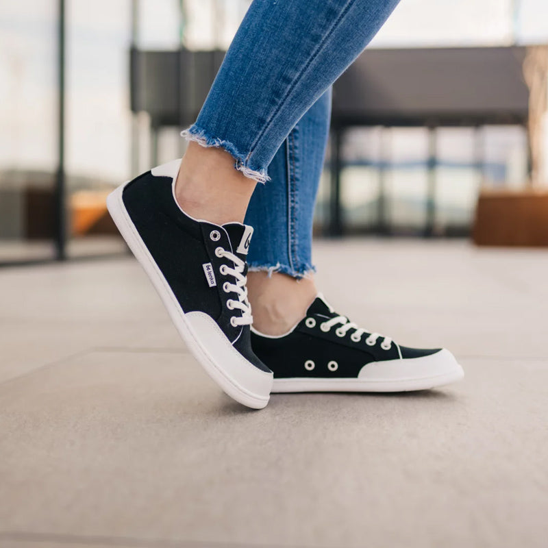 Person wearing Be Lenka Adults Trainers Rebound - Black and White with denim jeans, side view