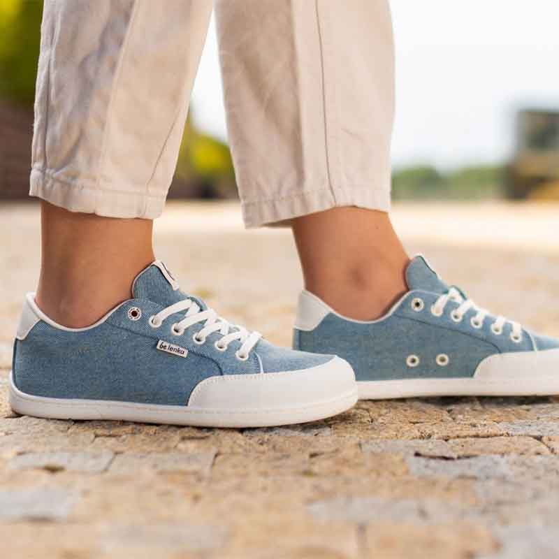 Person wearing Be Lenka Adults Trainers Rebound - Denim Light Blue with cream trousers, side view