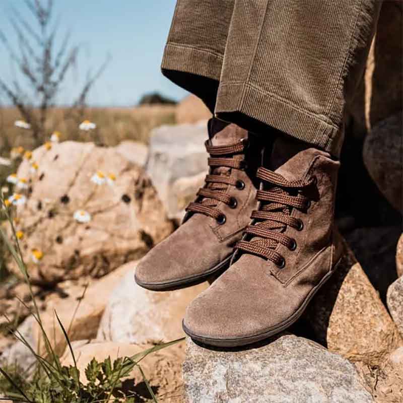 Person wearing Groundies Women's Ankle Boots Salzburg - Dark Brown with  brown trousers.
