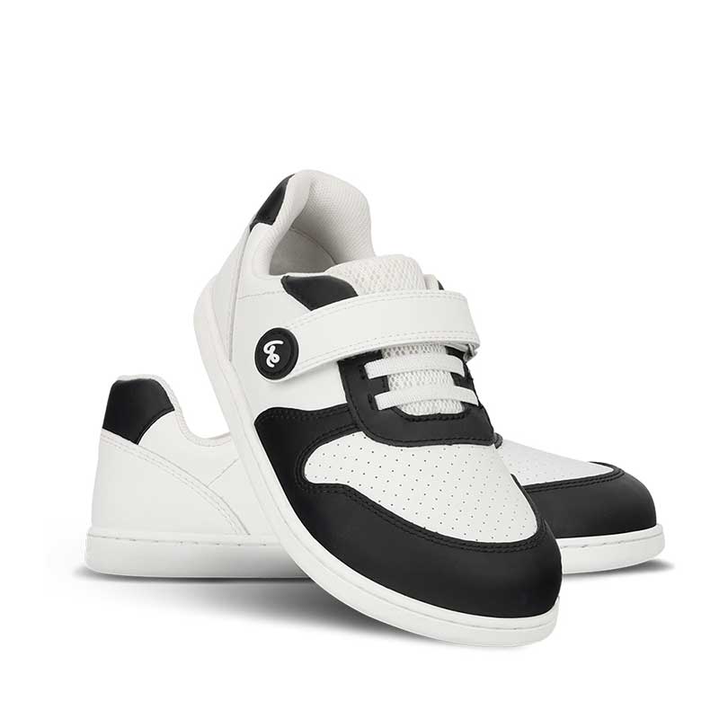 Pair of Be Lenka Kids Trainers Scoot - Black and White, one angled and leaning showing the outer side, the other partially showing the inner side