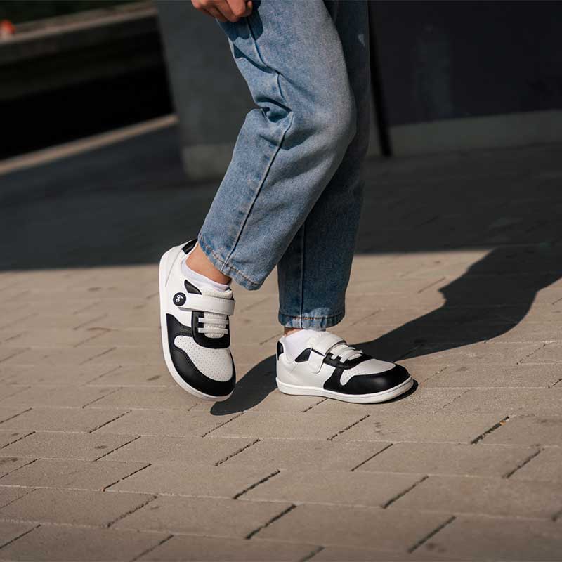Person wearing Be Lenka Kids Trainers Scoot - Black and White with denim jeans