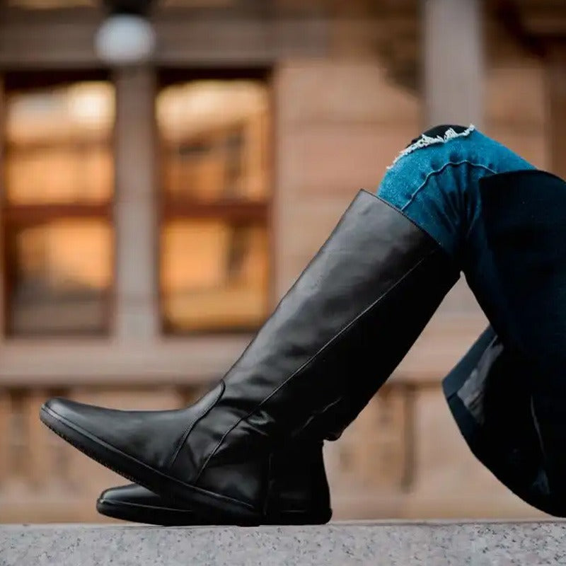 Person wearing Angles Women's Tall Boots Thalia - Black with blue ripped jeans