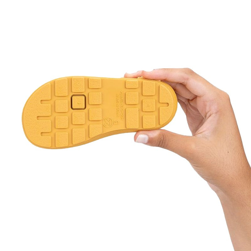 Person holding Igor Yogi Barefoot Warm Wellington Boots - Amarillo Yellow, sole view.