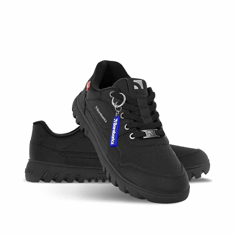Be Lenka Adults Barebarics Trainers Zing Frost - All Black, one angled and leaning showing the outer side and Barebarics keyring, the other partially showing the inner side
