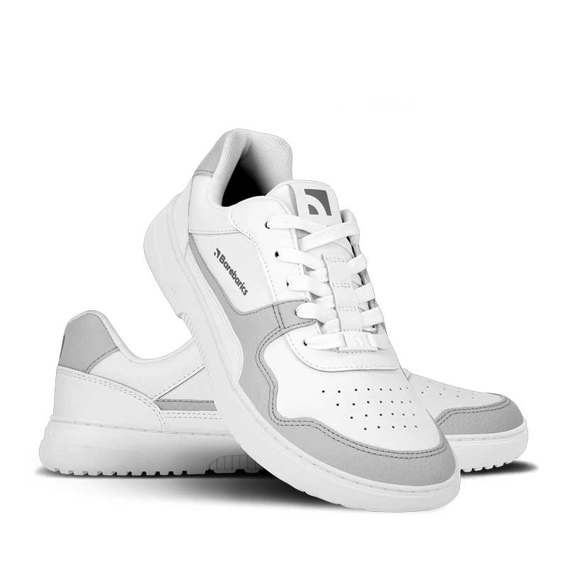 Pair of Be Lenka Adults Barebarics Leather Trainers Zing - White and Light Grey, one angled and leaning showing the outer side, the other partially showing the inner side